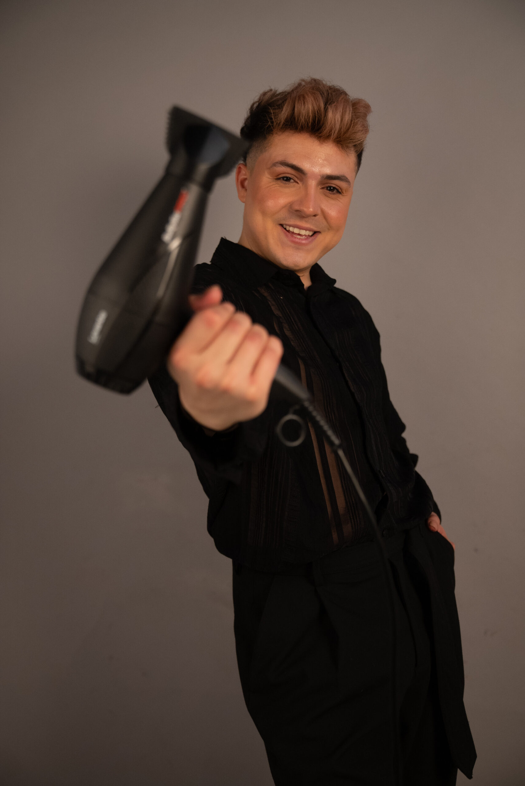 Estilista Freddy Moreno posando con un secador